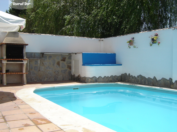 Terraza con barbacoa y piscina de la casa rural La Vega