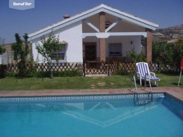 vista piscina, jardín y porche de la casa rural Rancho Bermejales