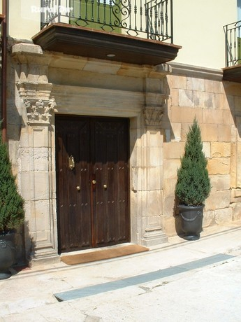 puerta principal con pinos de la casa rural Casa de valle