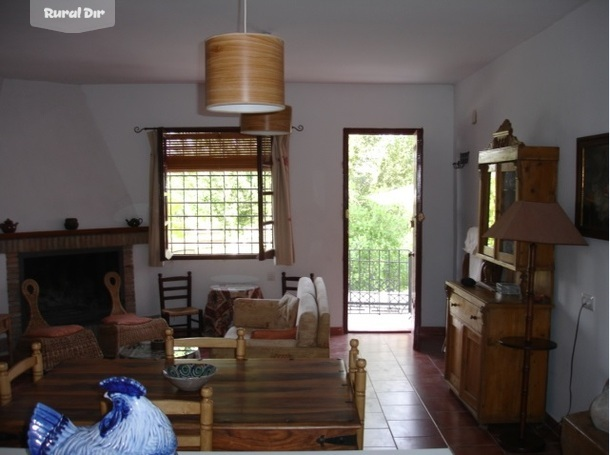 parte del salon con la chimenea de la casa rural Casa de la Acequia en Cortijo el Cosio