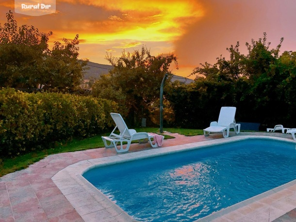 Atardecer en la piscina privada del jardín de Casa Salva de la casa rural Casa Salva