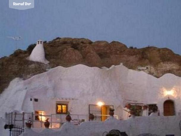 Fachada a la noche de la casa rural Cueva Almendro